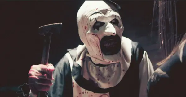 Image of a clown brandishing a hatchet—and baring a mouthful of bloody teeth.